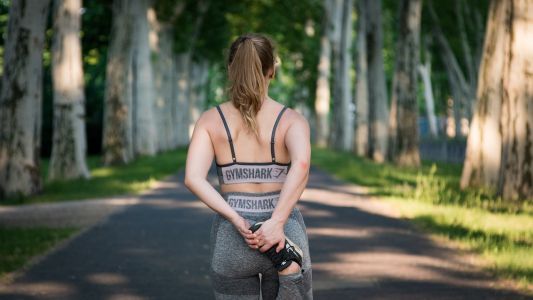 donna che corre all'aperto, di schiena, in una giornata di primavera
