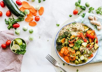 tovaglia bianca con flatlay di ciotola di cibo fresco e colorato, usato per articolo su cosa mangiare quando fa caldo