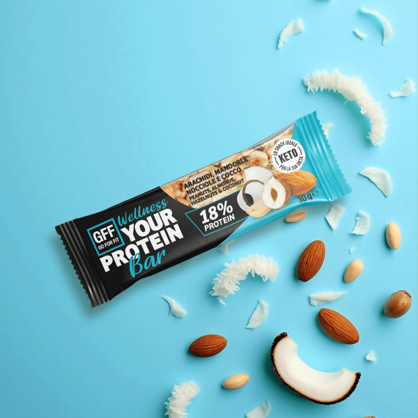 Barretta proteica GFF con arachidi, mandorle, nocciole e scaglie di cocco su sfondo azzurro vivace