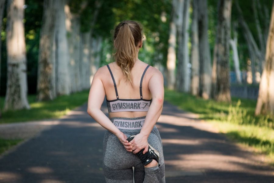 donna che corre all'aperto, di schiena, in una giornata di primavera